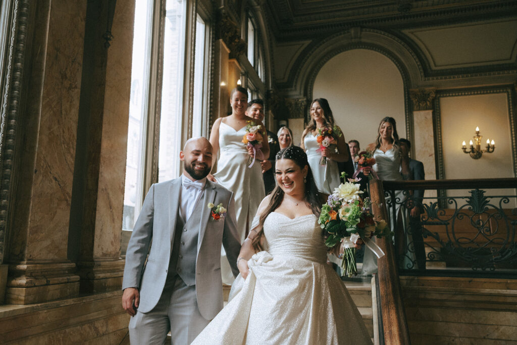 Couple and their wedding party walking down the grand staircase at the Providence Public Library for their nontraditional wedding!