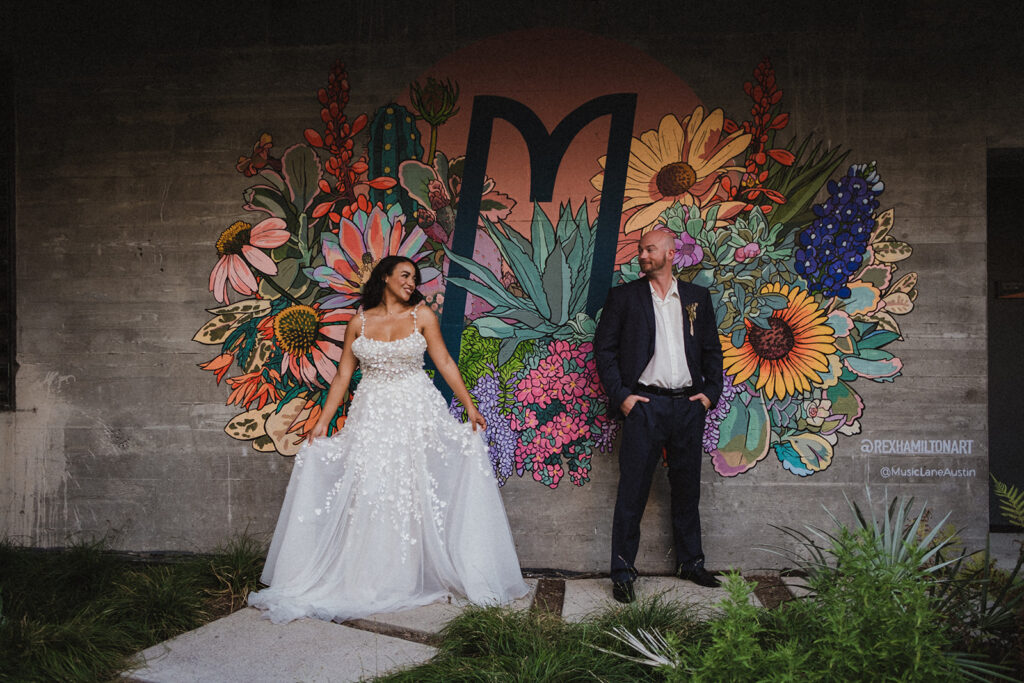 Couple eloping in Austin, Texas pictured in front of a mural of flowers