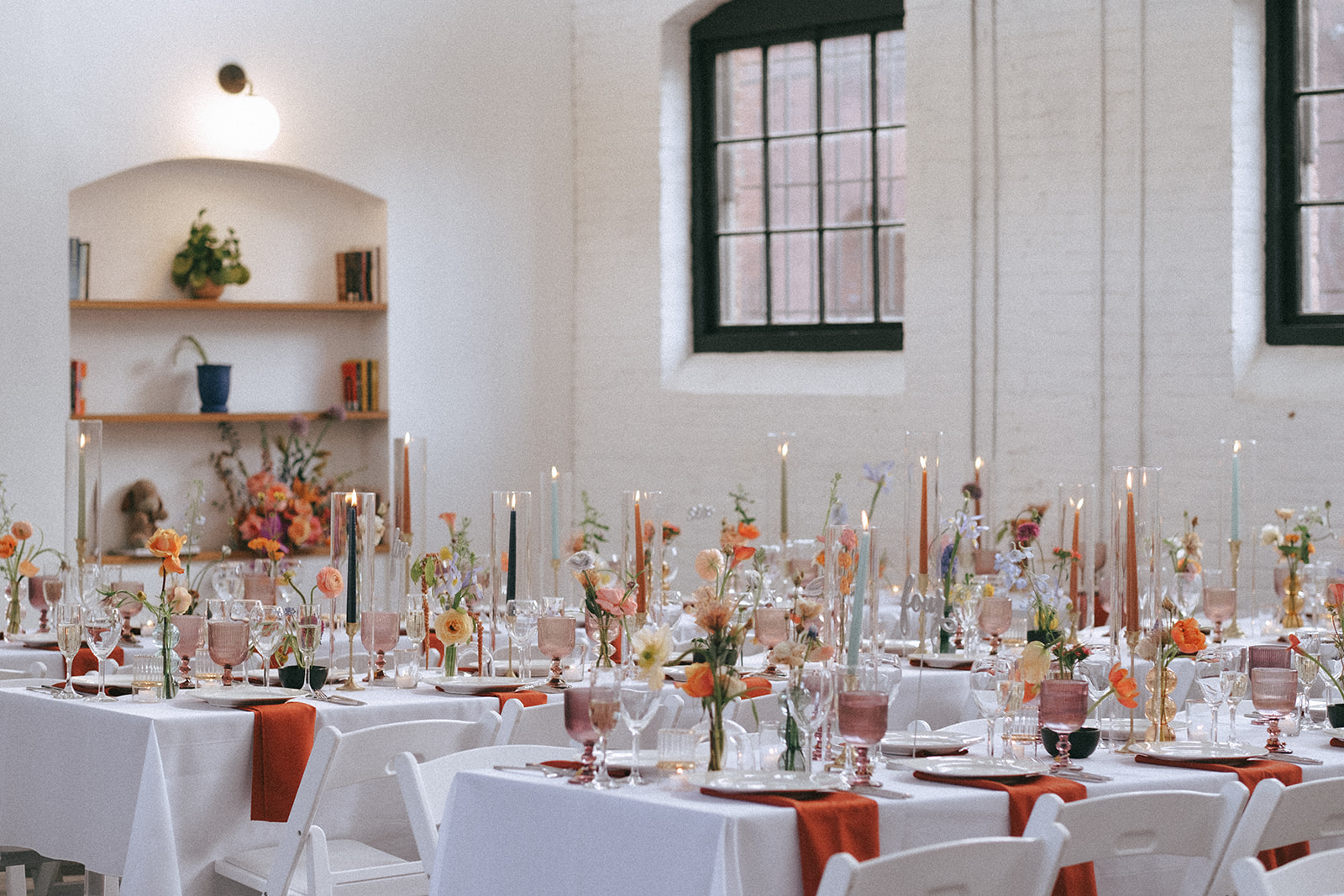 wedding tables with candles and place settings in bright colors inside of Dye House - a loft style wedding venue in Providence, RI