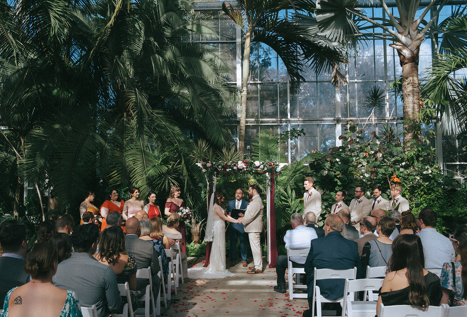 Bride and groom's wedding ceremony inside the Roger Williams Park Botanical Center greenhouse.