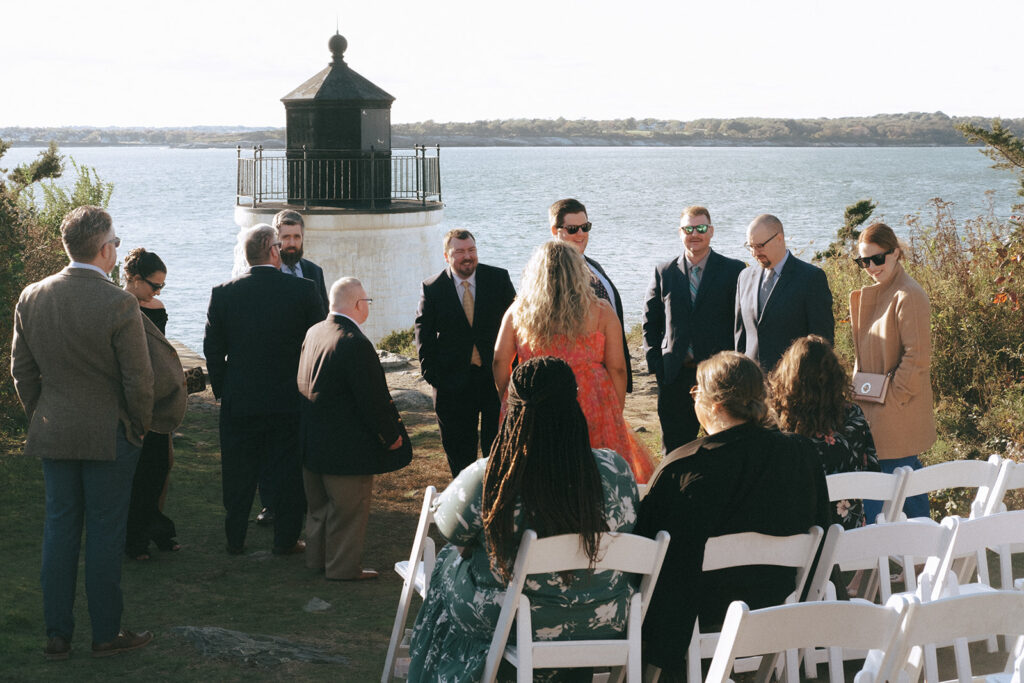 Guests mingle in front of the Castle Hill Lighthouse as they wait for the wedding ceremony to begin. Photo by Rhode Tripper Photography