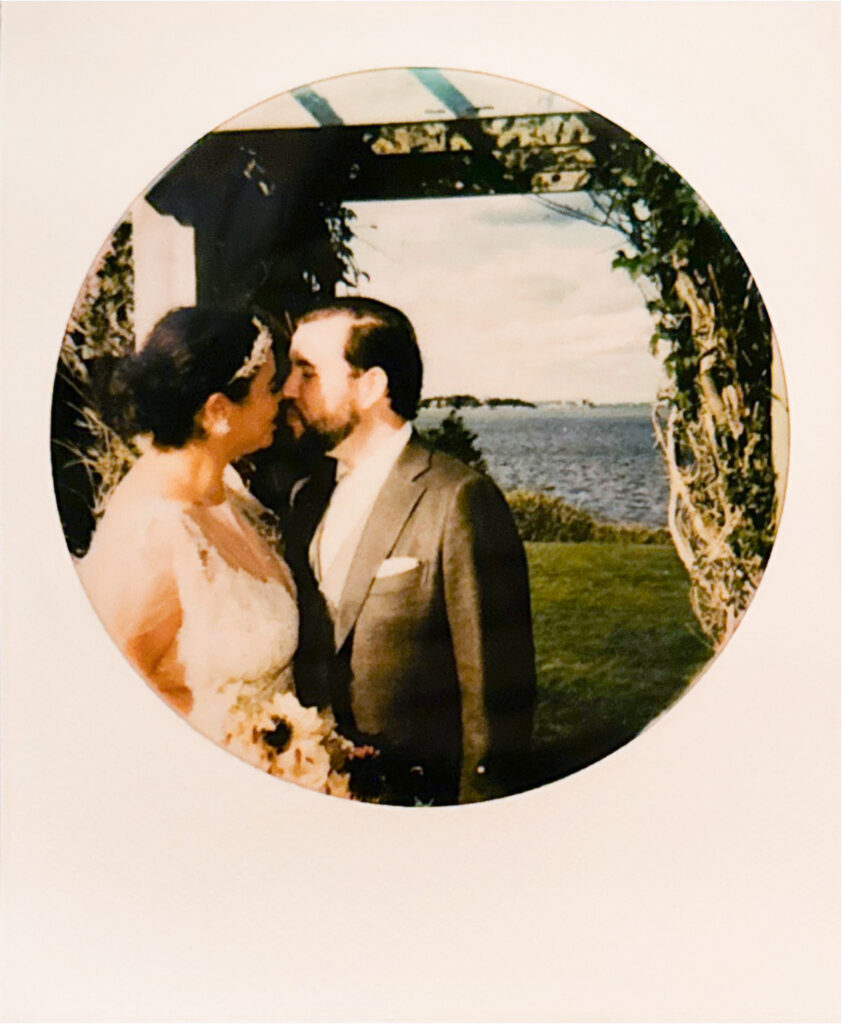 Polaroid scan of bride and groom about to kiss under the pergola at Castle Hill Inn. Water and coastline serves as the background. Photo by Rhode Tripper Photography