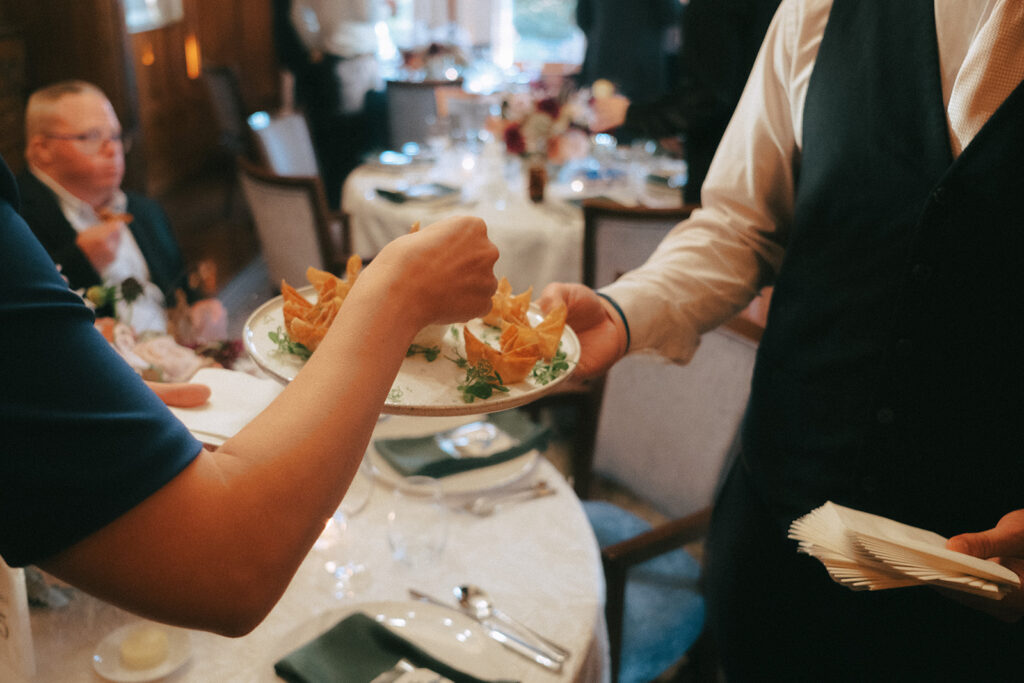 Wedding guest reaches for an hors d'oeuvre at a Castle Hill wedding. Photo by Rhode Tripper Photography