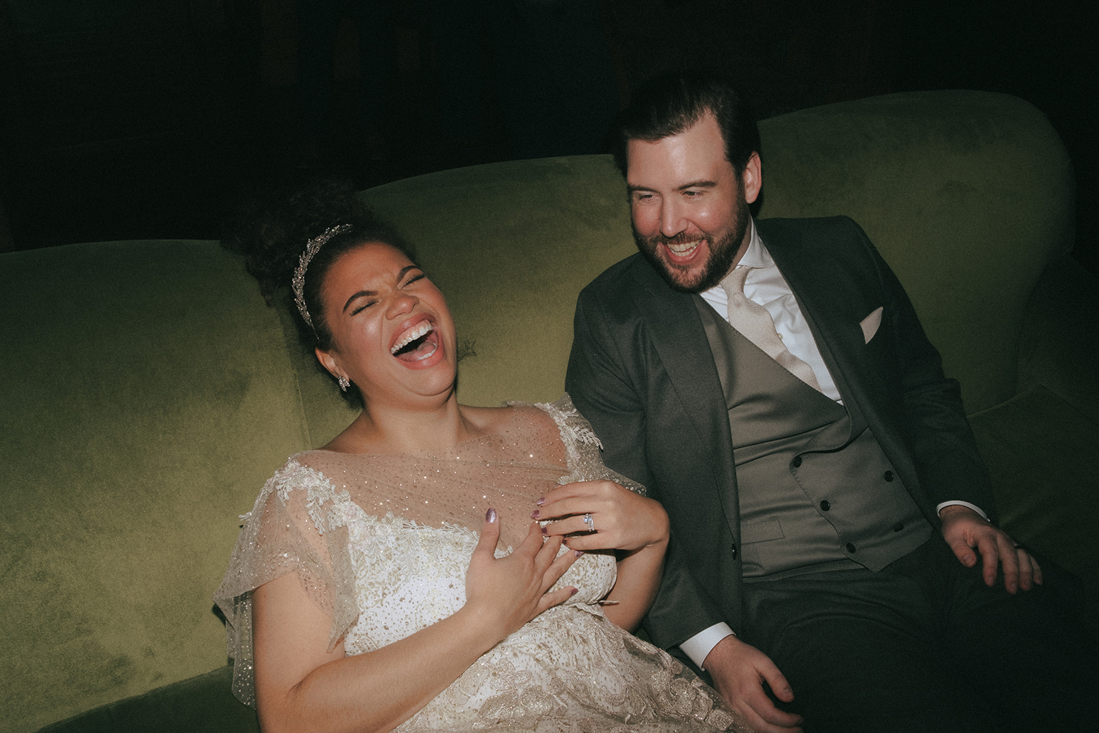 Relaxed bride and groom laughing during evening wedding reception