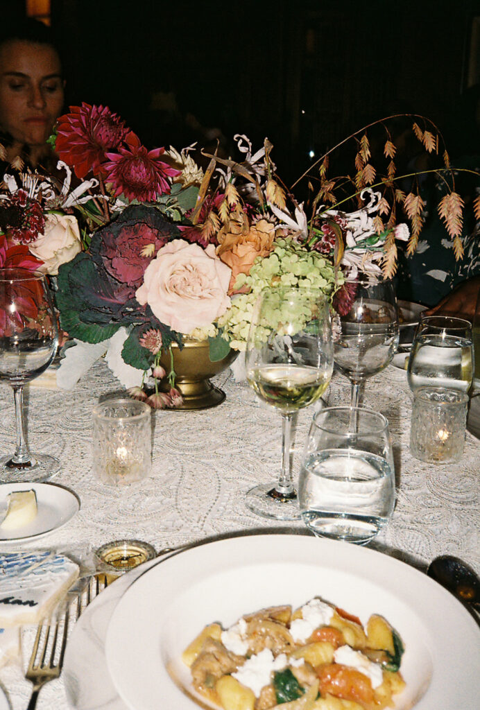 Glasses, florals, and the first course sit atop this guest table at a Castle Hill Inn wedding dinner. Photo by Rhode Tripper Photography