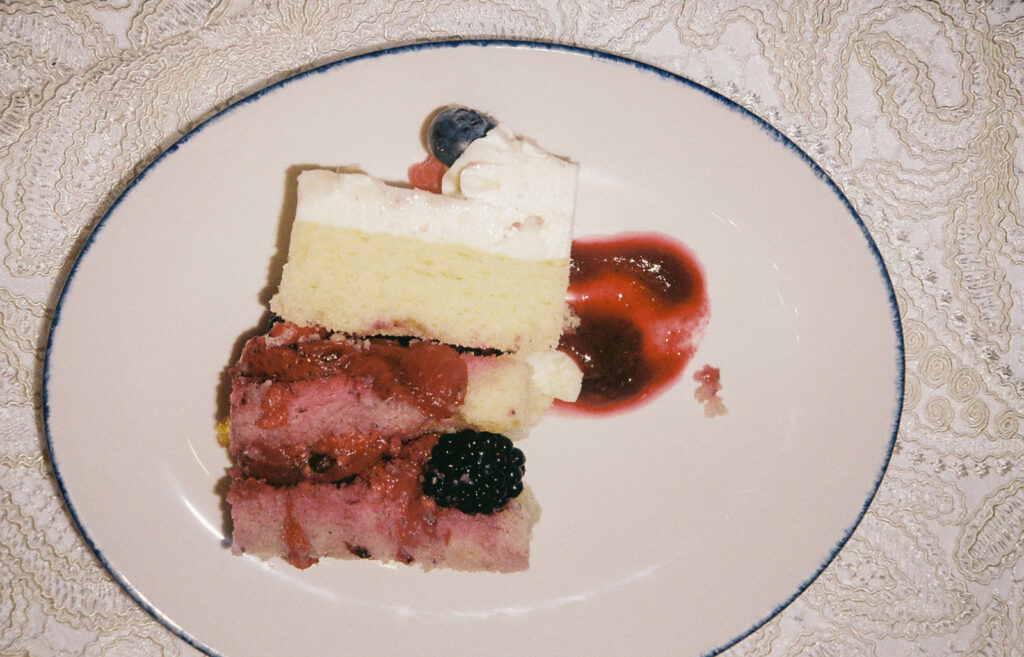 Slice of vanilla cake with berries oozing out of it. Wedding cake at Castle Hill Inn wedding. Photo by Rhode Tripper Photography