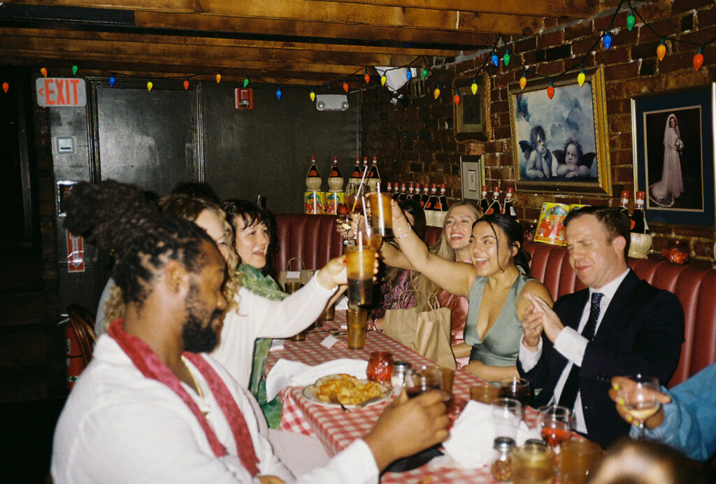 Guests toast to the bride and groom at Tony and Elaine's Italian Restaurant in Boston.