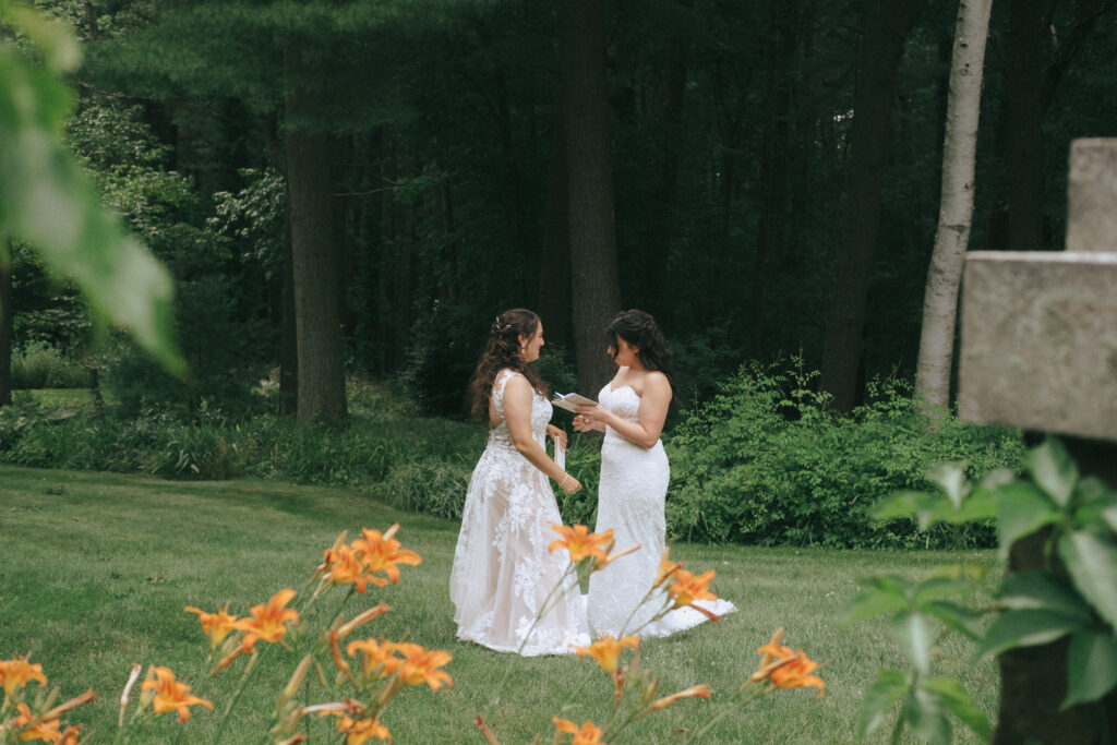 Emotional first look between two brides in a garden setting.