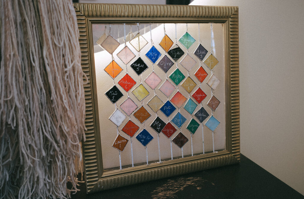 Glass charm name cards on seating chart at wedding in Providence. Photo by Rhode Tripper Photography