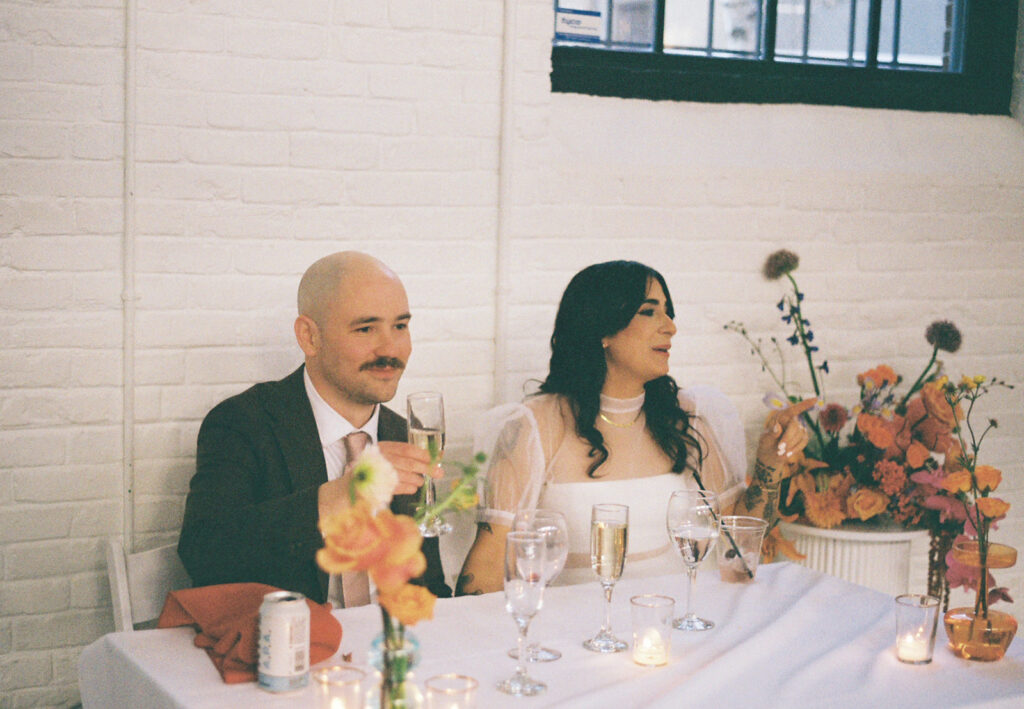 Bride and groom's sweetheart table with retro decor at boutique hotel venue. Photo by Rhode Tripper Photography