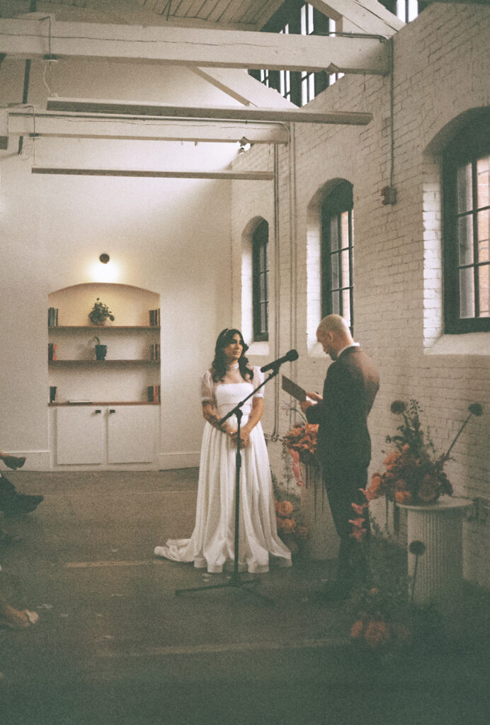 Couple exchanging vows at industrial chic boutique hotel venue in Providence. Photo by Rhode Tripper Photography