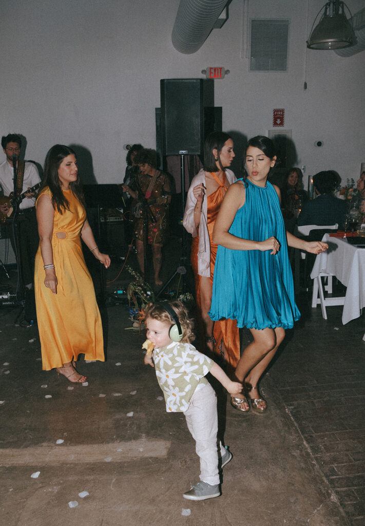 Candid moments of wedding guests enjoying a live reception band. Photo by Rhode Tripper Photography