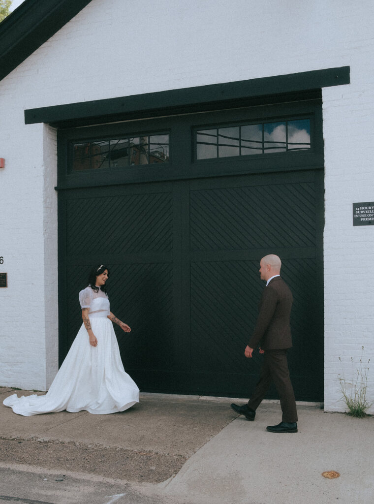 Bride and groom seeing each other for first time outside boutique hotel venue. Photo by Rhode Tripper Photography