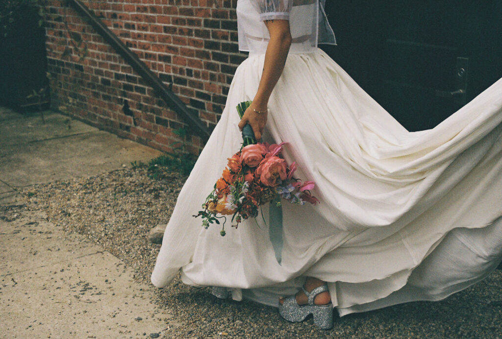 Detailed shot on 35mm film of colorful spring wedding bouquet with peonies and orchids at boutique hotel. Photo by Rhode Tripper Photography