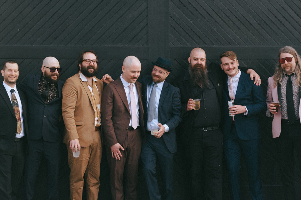 Groom and groomsmen in colorful attire at spring boutique hotel wedding. Photo by Rhode Tripper Photography