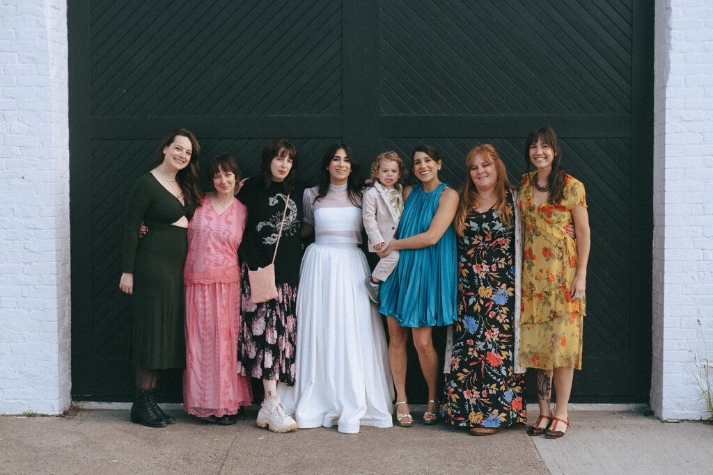 Large family and friends group photo in front of boutique hotel venue in spring. Photo by Rhode Tripper Photography