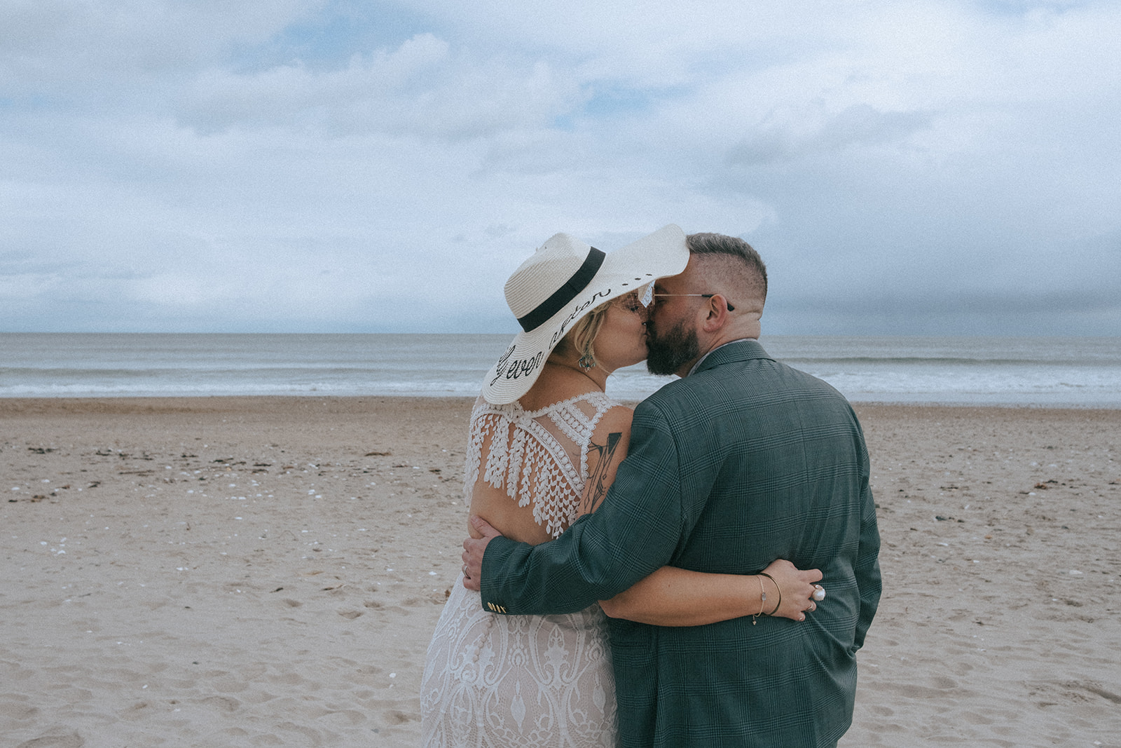 Bride and groom kissing on the beach at their North Beach Clubhouse Wedding.