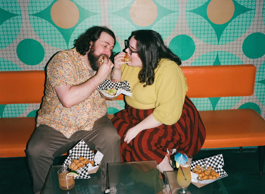 Couple eating sandwiches from Granny Boo's Kitchen at Ogie's Trailer Park for their restaurant wedding in Providence.